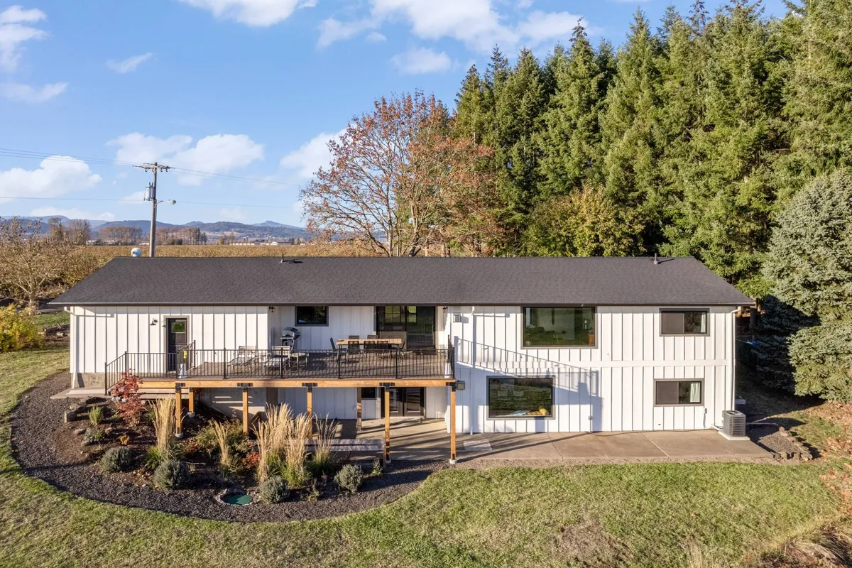 An outdoor deck furnished with seating and surrounded by lush greenery, seamlessly extending the living space outdoors. The deck is positioned for enjoying sunsets and the tranquility of the landscape.